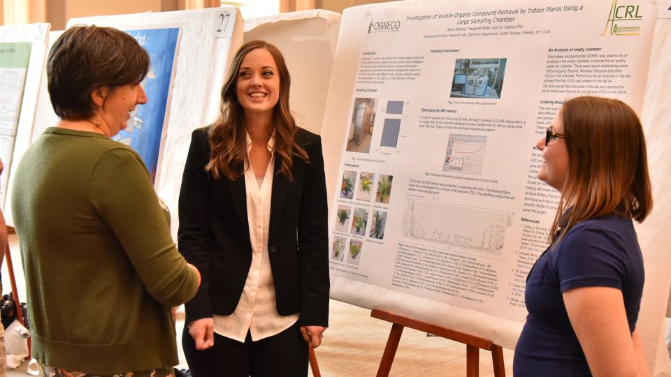 Julia Koeppe speaks with students Anna Makara and Maggie Miller about their research in analytical chemistry