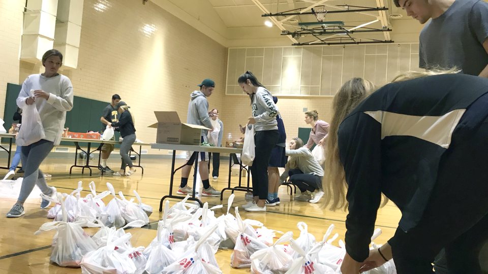 Laker student-athletes packing bags of food