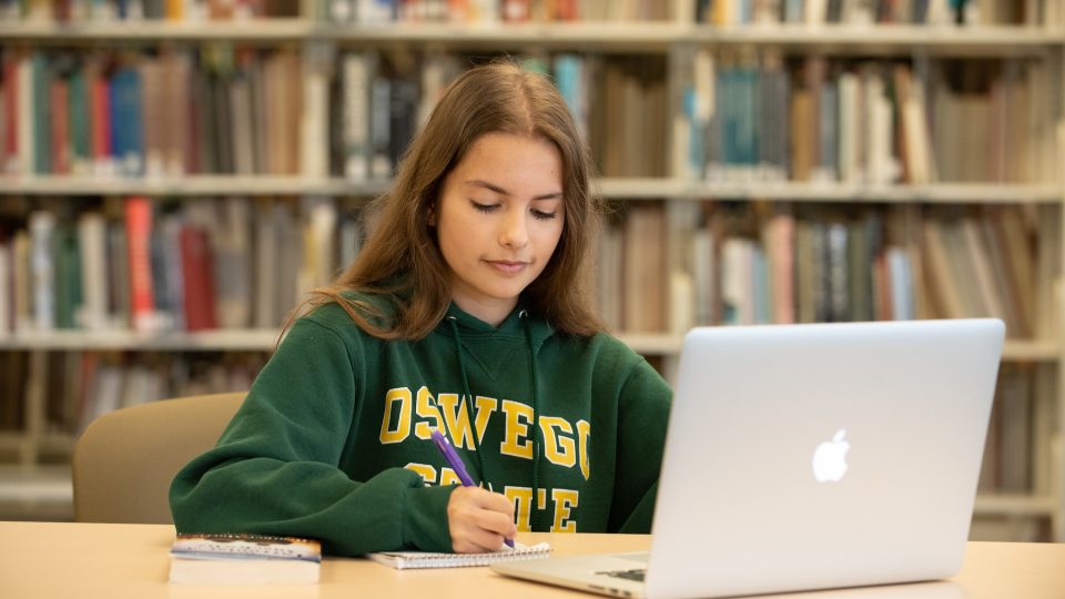 Student on a laptop in Penfield Library