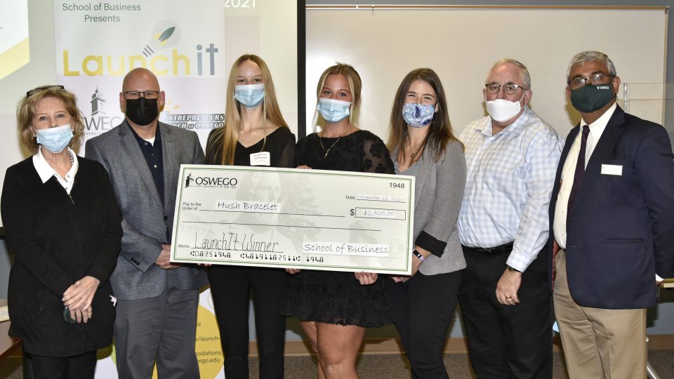 Launch It 2021 winners Molly Bergin and Robyn Kilts with judges and organizers holding a $2500 check
