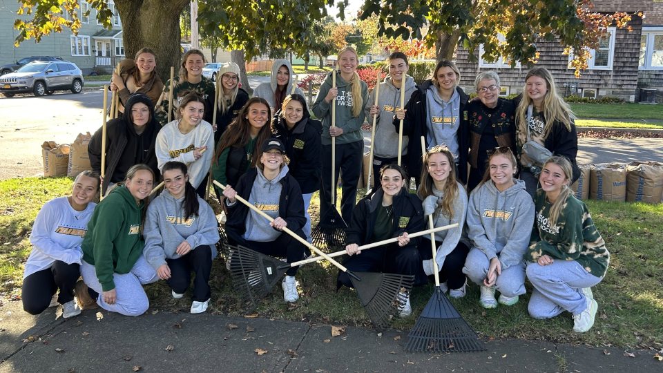 Laker field hockey team poses together after raking a yard
