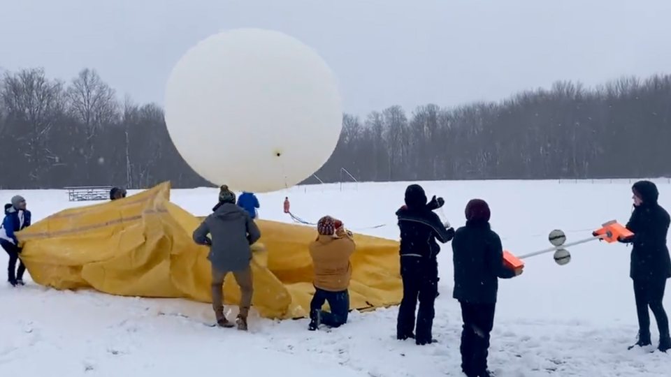 Students taking part in a lake-effect lighting study launch a huge weather balloon with attached instrumentation to measure conditions inside a winter storm cloud.