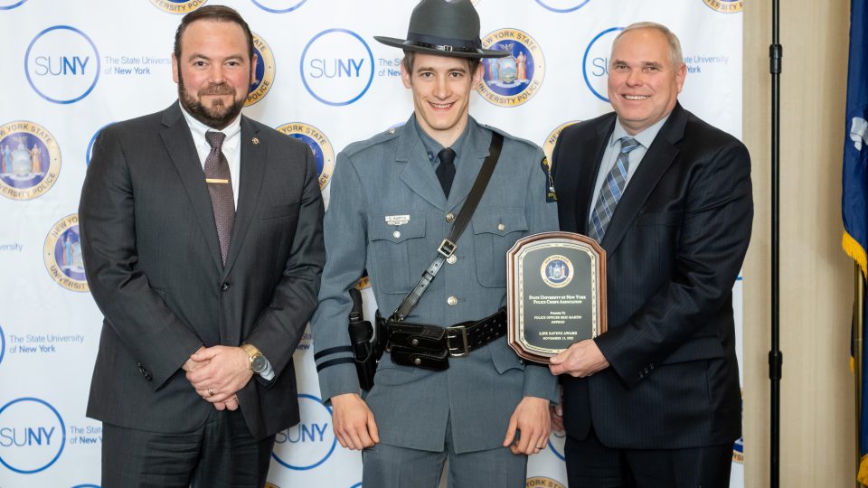 SUNY Oswego University Police Officer Eric Martin (center) earned honors during the 2022 University Police Awards; here he is congratulated by Chief Scott Swayze and Kevin Velzy, who retired as chief earlier this year