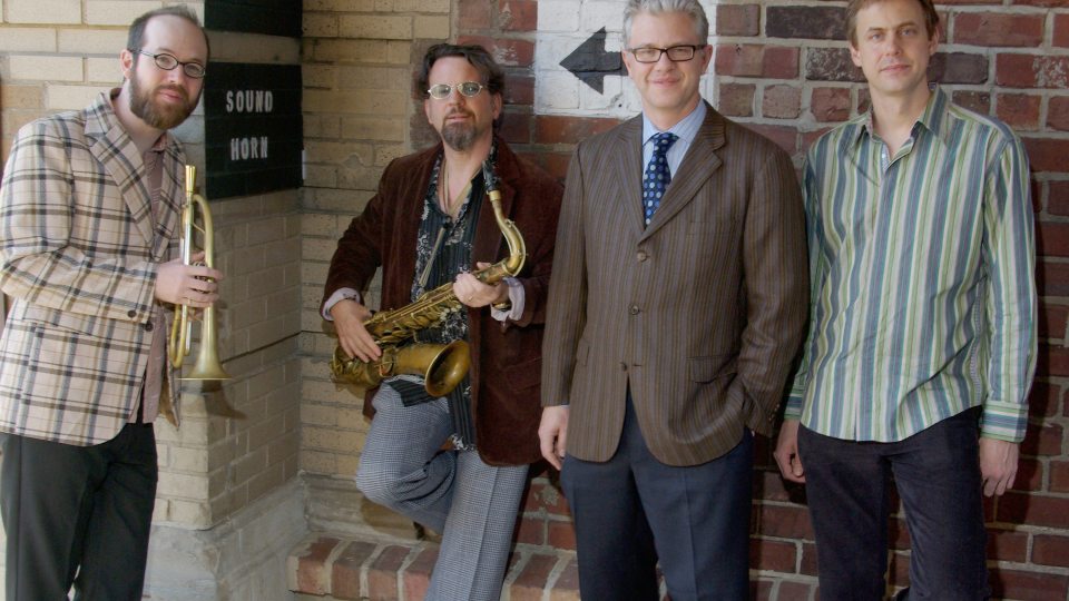 Matt Wilson Quartet standing against a wall