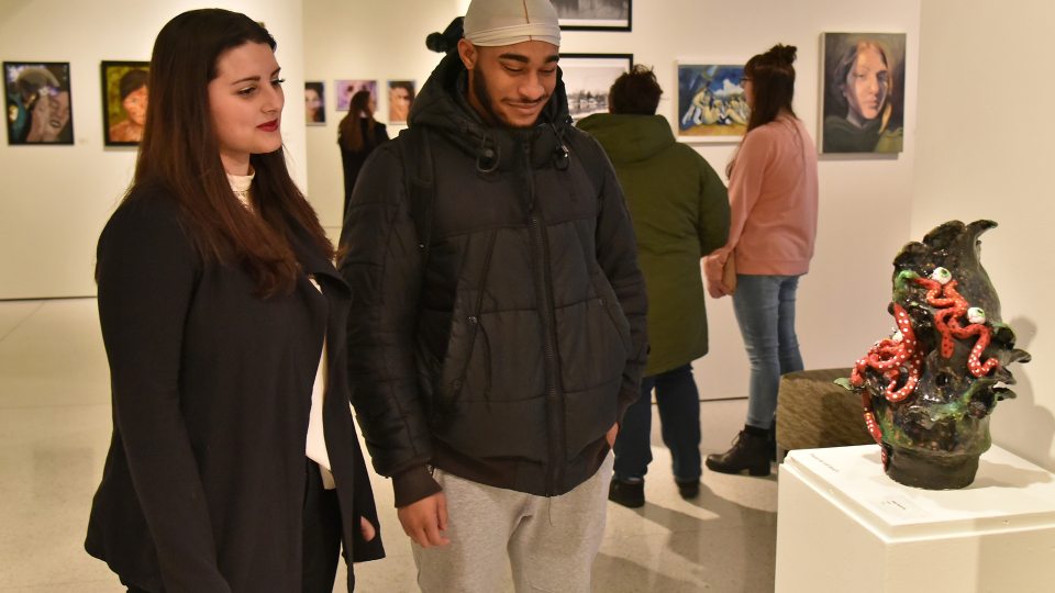 Shea McCarthy looks at her sculpture during Juried Student Exhibition