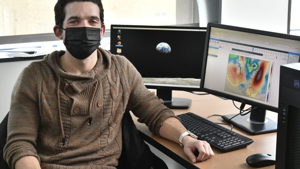 Adam Nahar working with weather modeling software in a meteorology lab