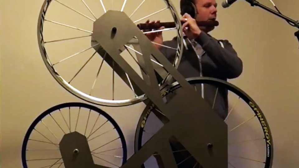 Music faculty member Paul Leary with instrument that combines flute with bicycle wheels