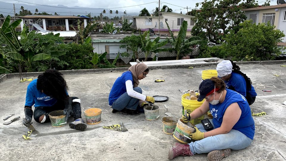 Students work on patching a roof in Puerto Rico