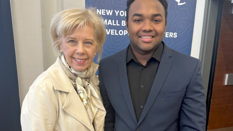 Irene Scruton, assistant dean of the School of Business and director of the university’s MBA programs, congratulates business administration major Price Flores for advancing to the statewide level of the New York State Business Plan Competition.