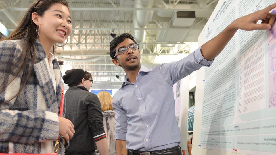 Student presenting poster at Quest