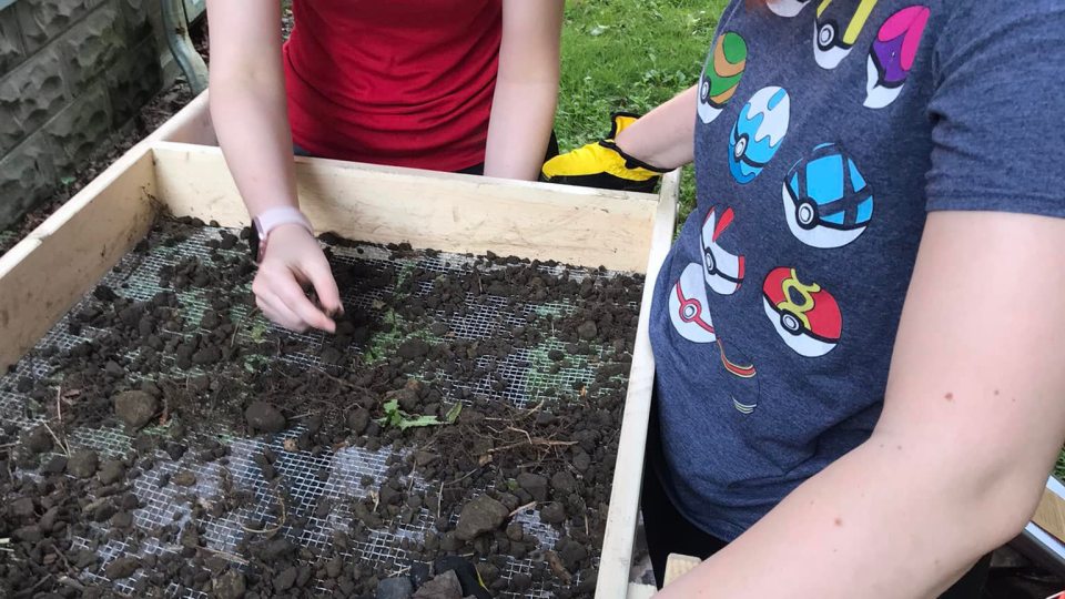 SUNY Oswego student archaeologists dig in while examining items they have unearthed at the local historic home and museum known as the Richardson-Bates House