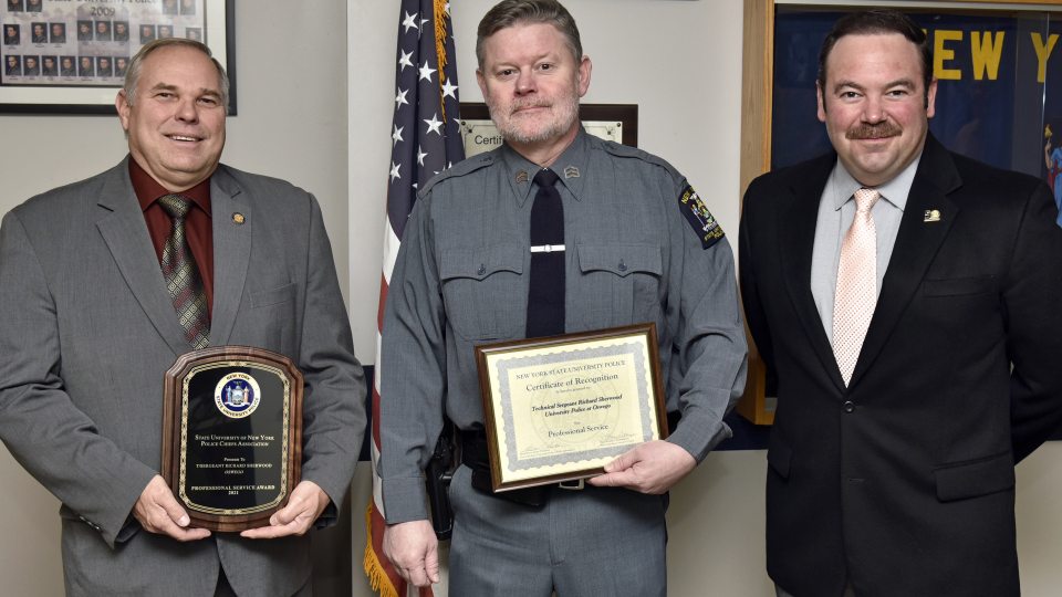 University Police Technical Sergeant Richard Sherwood was named recipient of a 2021 SUNY University Police Professional Service Award. Sherwood, center, is congratulated by University Police Chief Kevin Velzy, left, and Assistant Chief Scott Swayze