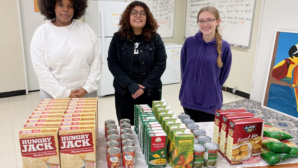Showing some contributions to SHOP's food drive are student volunteer Issagha Bah; April Lopez, assistant dean of students, basic needs case manager and homeless liaison for the Office of the Dean of Students; and student volunteer Alexis Chainao.