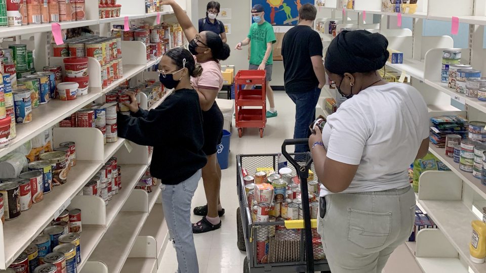 Student volunteers help stock shelves for the SHOP food pantry