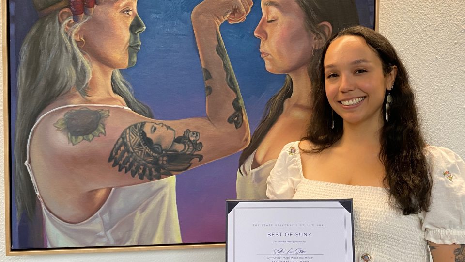 Sofia Luz Pérez stands next to her award winning painting