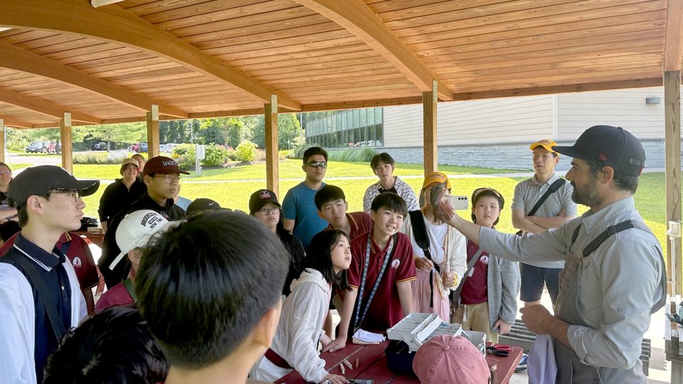 Biological science faculty member Daniel Baldassarre provides an ornithology lesson to visiting students from South Korea