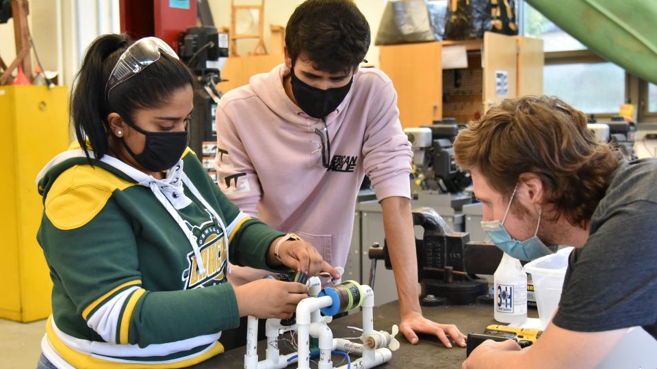 Three students work in a SUNY Oswego energy technology laboratory in Wilber Hall