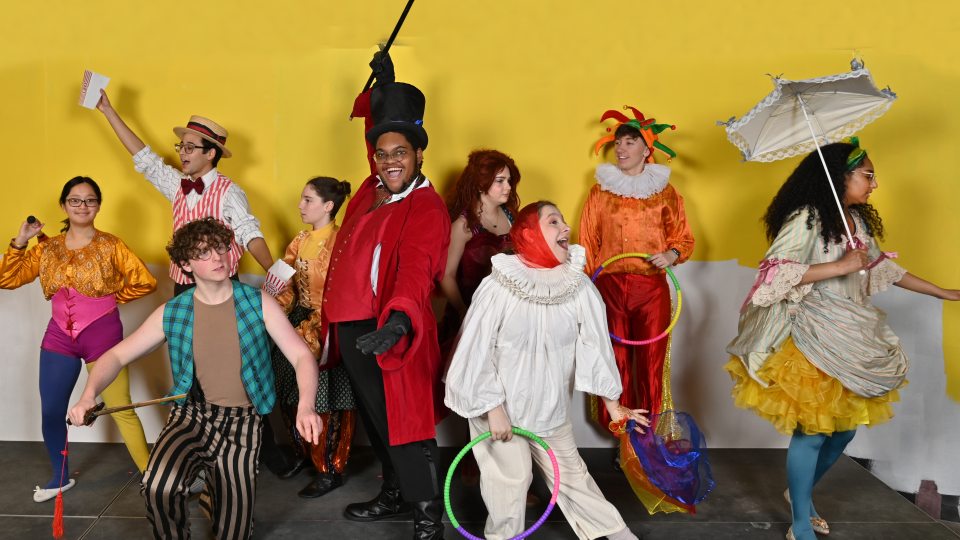 Performers in circus attire pose in a production image for Tuck Everlasting