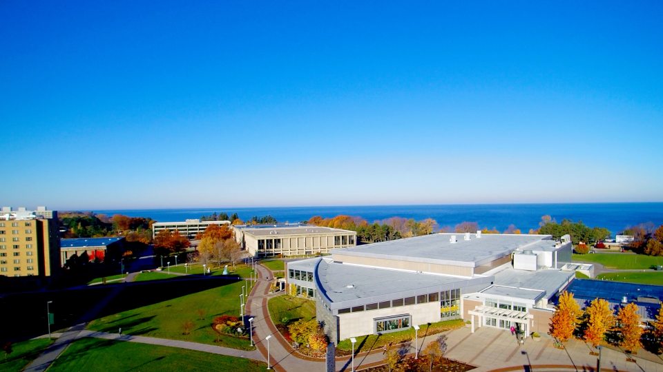 Aerial view of campus with fall foliage and Lake Ontario