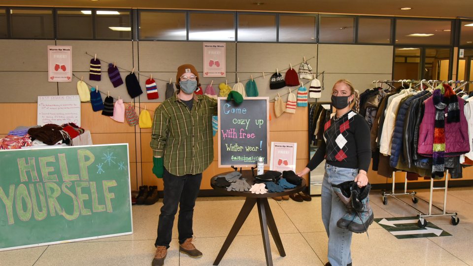 Sustainability Office students showing off coats, boots, hats, gloves and scarves available for free
