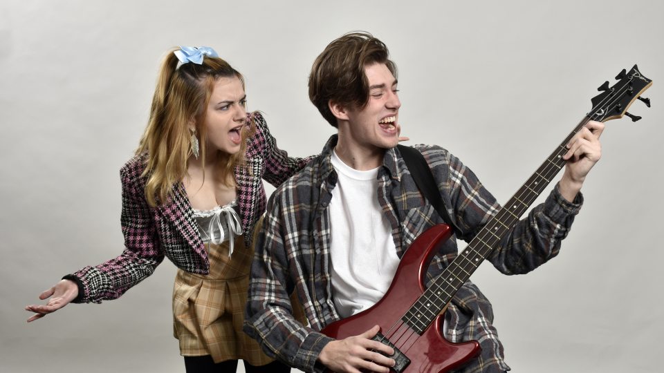 Rachel Leotta, at left, and Brock Whaley, at right playing a bass, are among the ensemble cast of The Wedding Singer