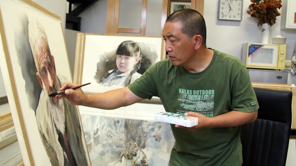 Artist Zhinan Jiang works on a watercolor painting