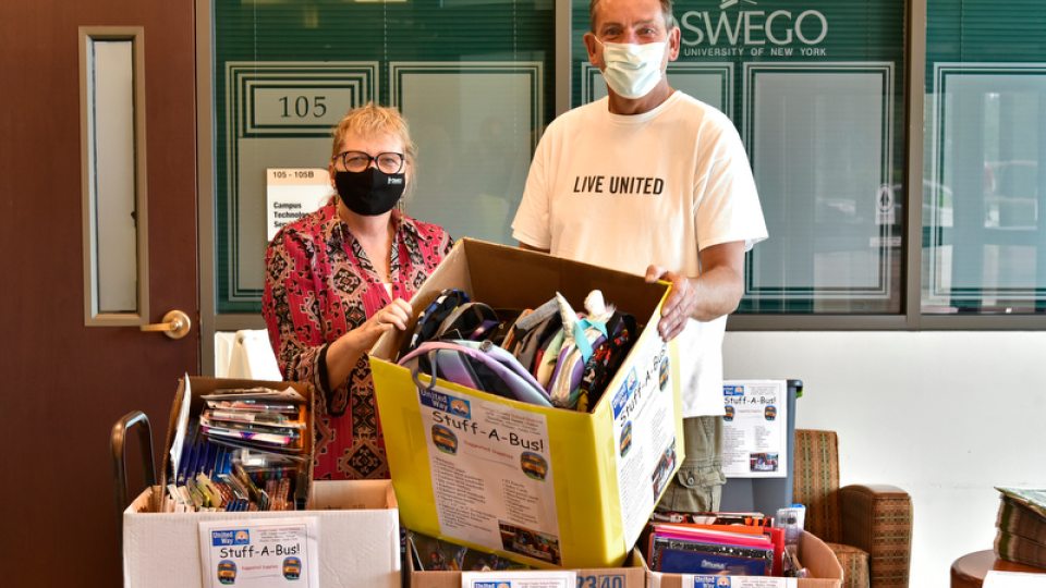 SUNY Oswego State Employees Federated Appeal co-chair Cathy Johnston and Patrick Dewine, executive director of the United Way of Greater Oswego County, with some of the supplies from the 2021 Stuff a Bus drive