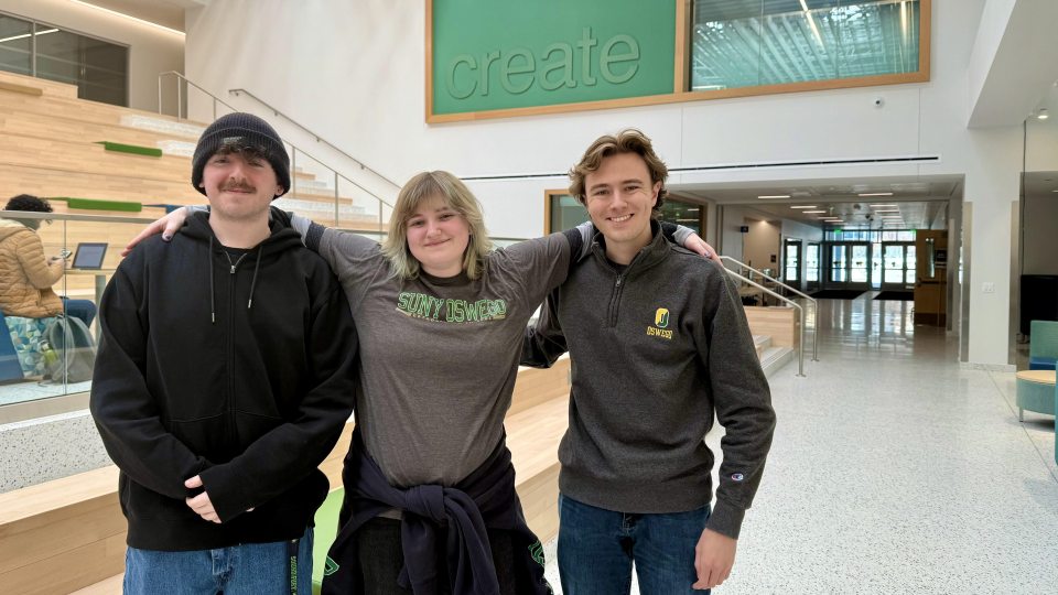 Three SUNY Oswego students pose in Hewitt Hall after placing in the 2026 BEA Awards