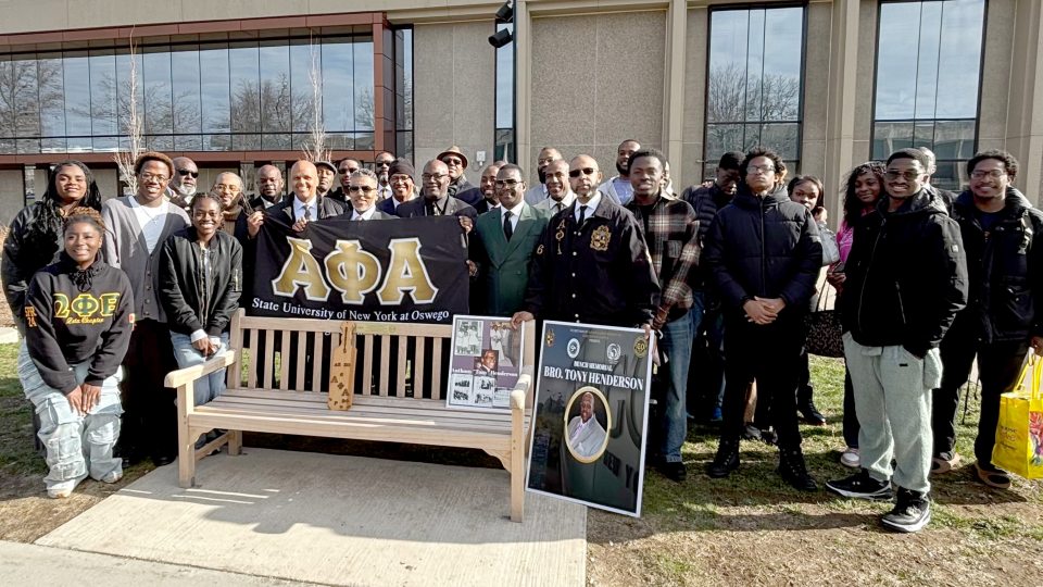 Members of Alpha Phi Alpha and the African Student Organization gather for the dedication of a bench to longtime residence hall director and mentor Tony Henderson