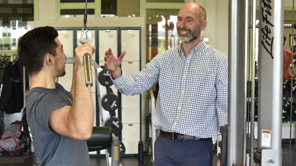 Brian Wallace in Cooper Fitness Center working with Panagiotis Vakirtzis, a junior business marketing major