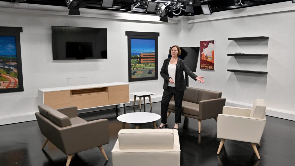 Jennifer Knapp, dean of SUNY Oswego's College of Communication, Media and the Arts, shows off a Hewitt Hall broadcast studio set to visitors just before the start of fall classes.