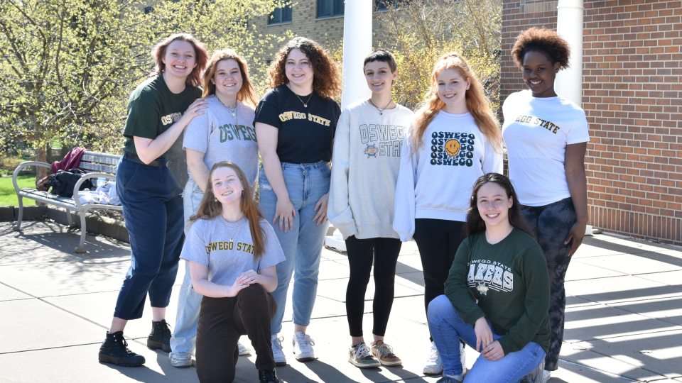 Students pose for a photo on the lakeside part of campus