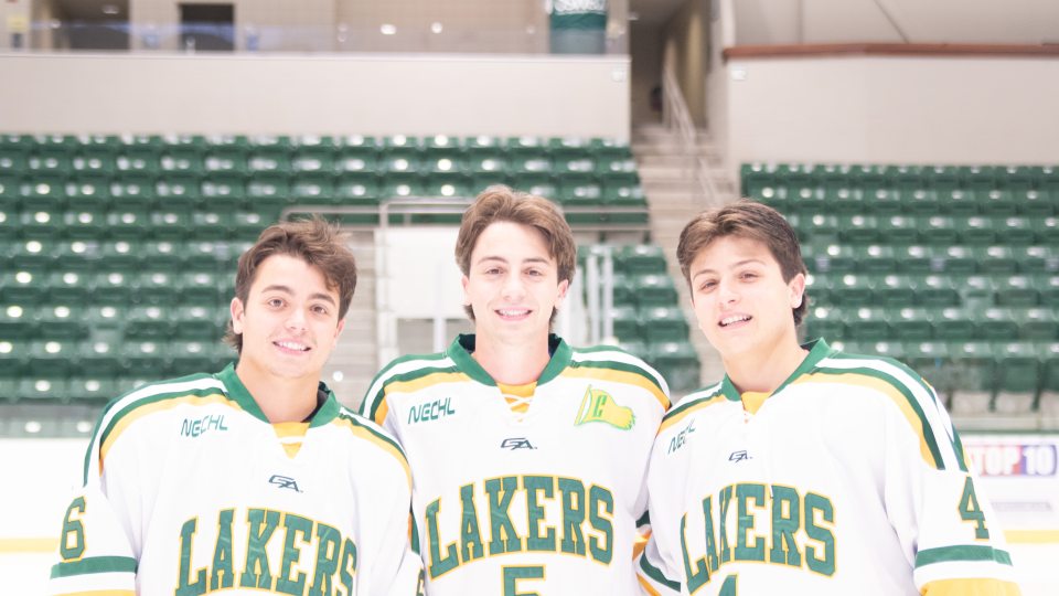 Matthew, Andrew, and Nicholas Cardi pose in hockey jerseys