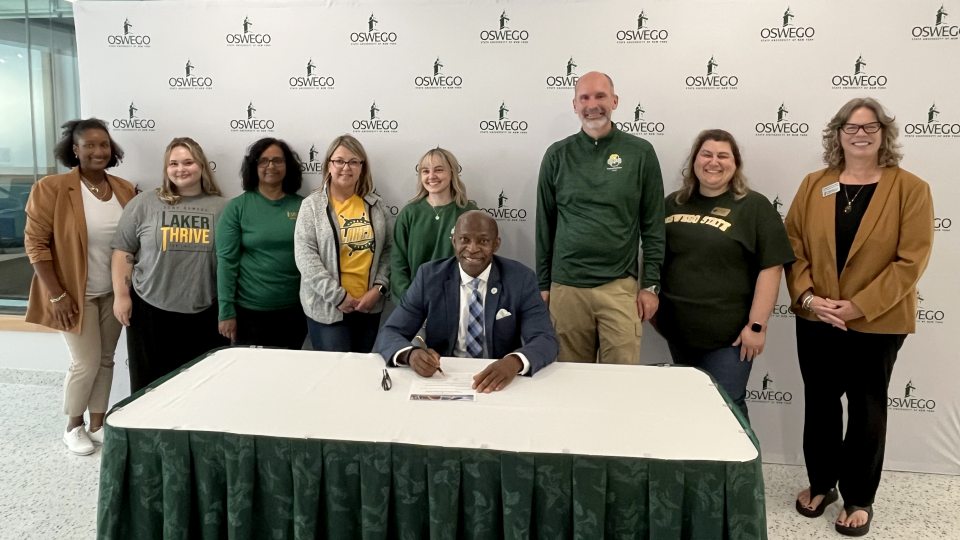 President Peter O. Nwosu, joined by members of SUNY Oswego's Campus Health and Well-being Committee, makes SUNY Oswego's participation the Okanagan Charter official with a charter signing on Friday, Sept. 26.