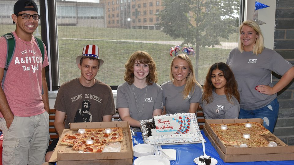 Students with pizza and cake at Constitution Day party in 2018