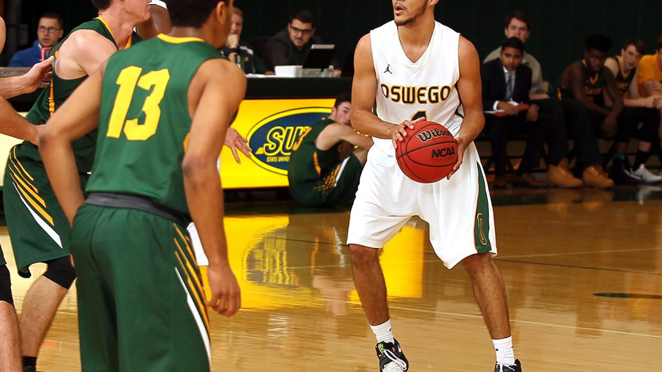 Laker men's basketball player dribbles the ball against defenders, looking for an opening