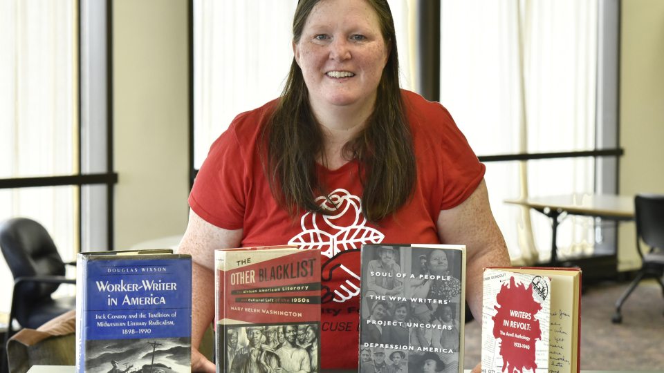 Maureen Curtin with books in Penfield Library