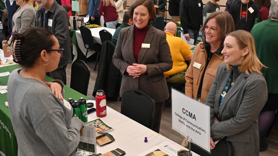 Lily Prado, a senior at George W. Fowler High School in Syracuse, speaks with College of Communication, Media and the Arts representatives (from left) Jennifer Knapp, dean; Kelly Roe, associate dean; and Davana Robedee, Tyler Art Gallery director.
