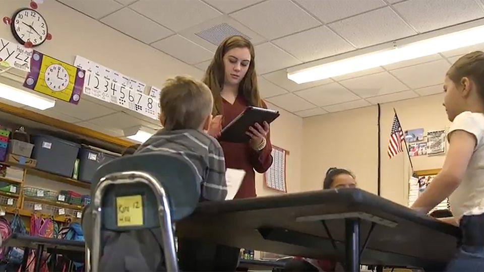 Student teacher works with schoolchildren