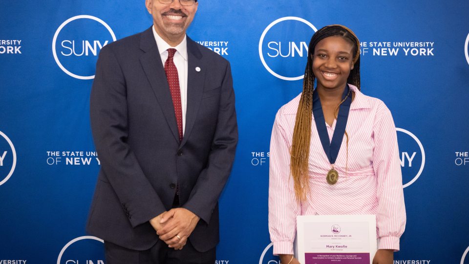 Chancellor John B. King Jr. congratulations SUNY Oswego student Mary Kwofie during an award ceremony