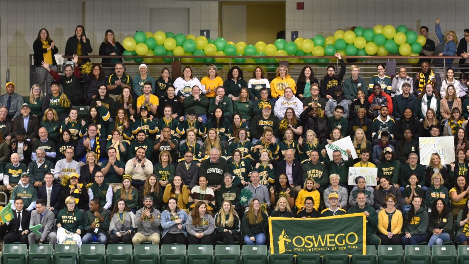Group of students, faculty, staff and alumni in green and gold