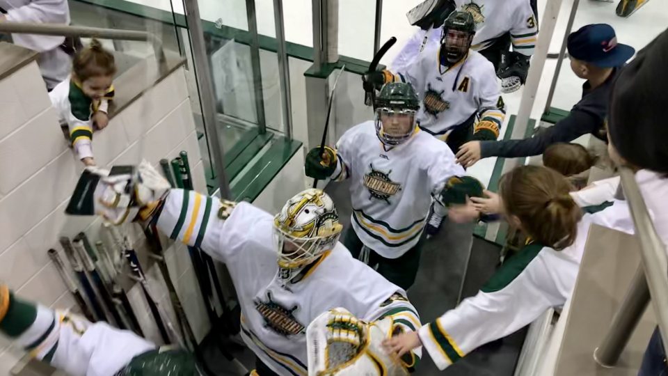 Men's hockey team high fives fans