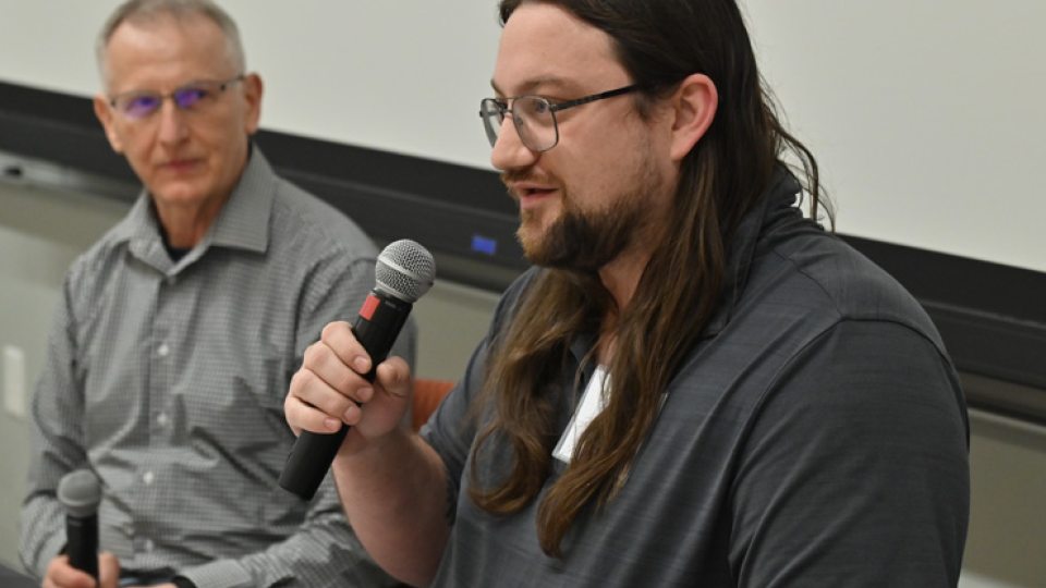 Kenny Roffo, a 2017 SUNY Oswego graduate whose accomplishments since included working on the InSight rover that landed on Mars for NASA, speaks to a full house as electrical and computer engineering faculty member Adrian Ieta looks on.
