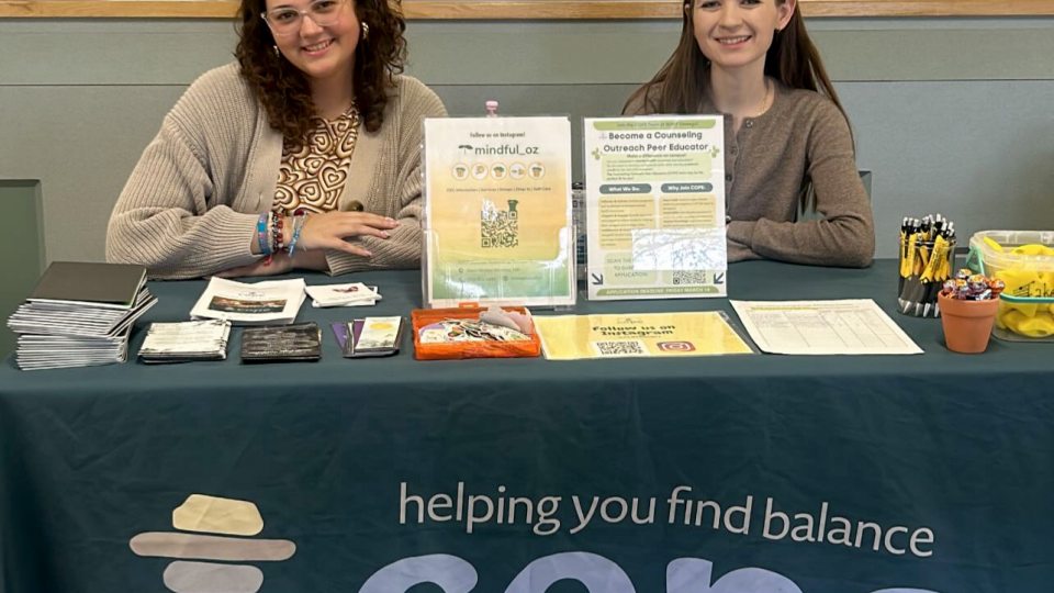 Patrycja Kulesza (right) and Madison Flood table for SUNY Oswego's Counseling Outreach Peer Educators