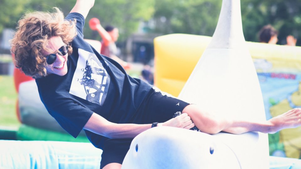 A student attempts to ride an inflatable shark at a previous year's LakerFest