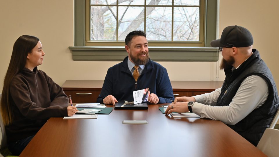 Ken Cisson meets with two students who came to SUNY Oswego after serving in the U.S. Air Force