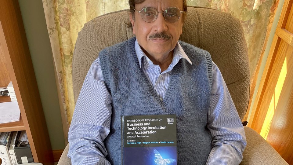 Sarfran Mian holds his most recent book, the first handbook for business incubation