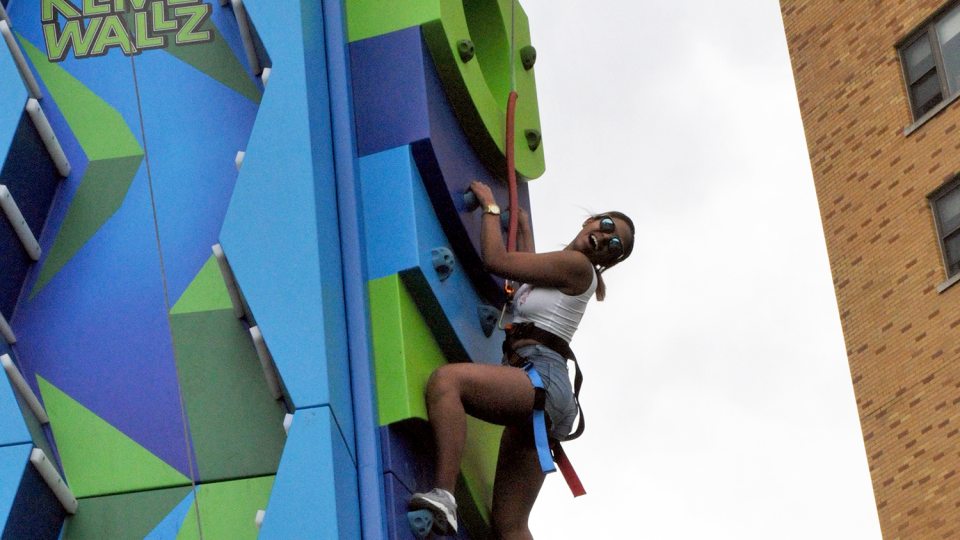 Student climbs an inflatable wall at OzFest