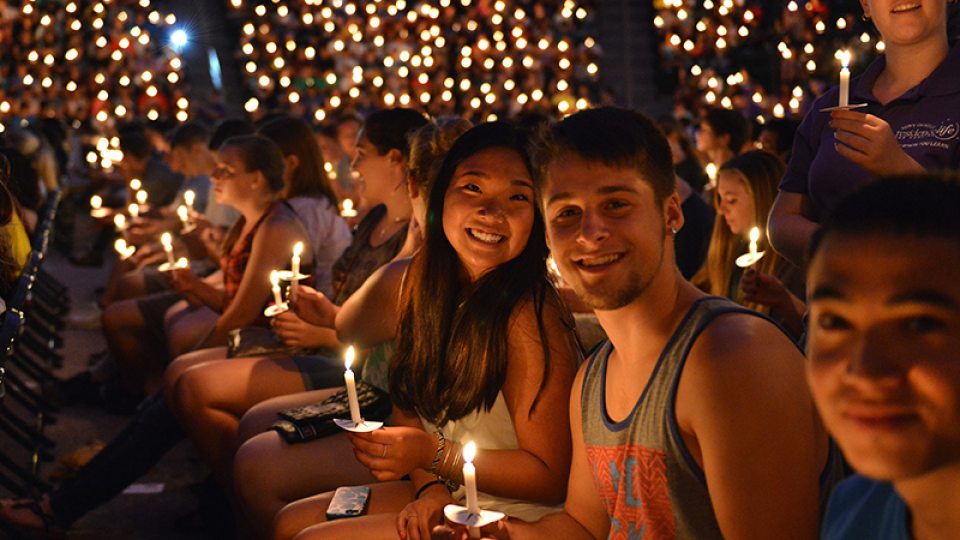 Students with lit candles at the Opening Torchlight Ceremony