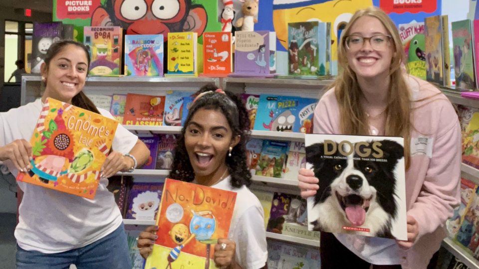 SUNY Oswego Empire State Service Corps member Ruby Remseyer makes friends while supporting a book fair at Leighton Elementary School in Oswego